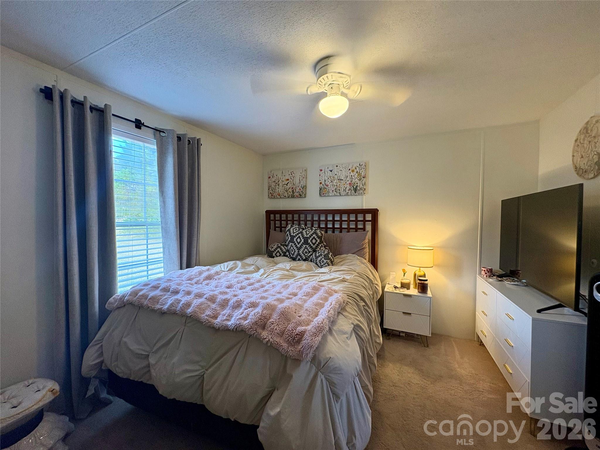 3422 Edwards Road Wingate, NC 28174 - Photo 27 of 31 a bedroom with a bed and a flat tv screen on dresser