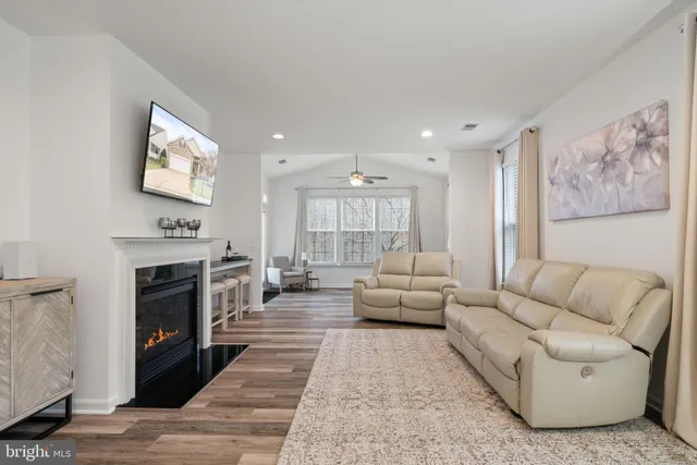 a living room with furniture a fireplace and a flat screen tv