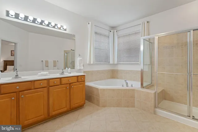 a spacious bathroom with a tub sink and mirror