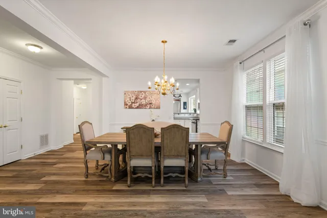 a dining room with furniture a chandelier and wooden floor
