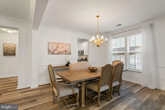 a dining room with furniture a chandelier and wooden floor