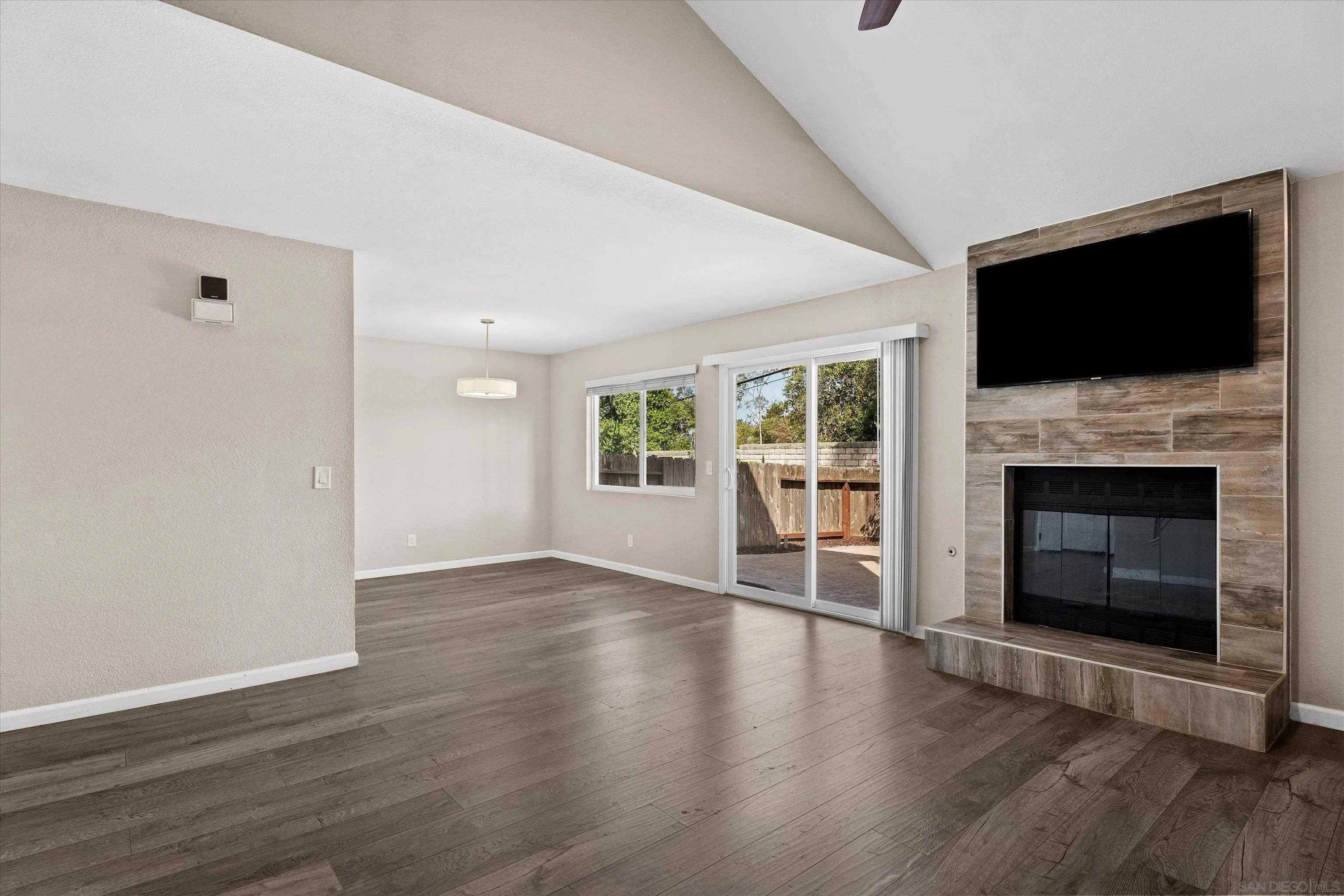 5636 Boot Way Oceanside, CA 92057 - Photo 2 of 36 a view of an empty room with wooden floor fireplace and a window