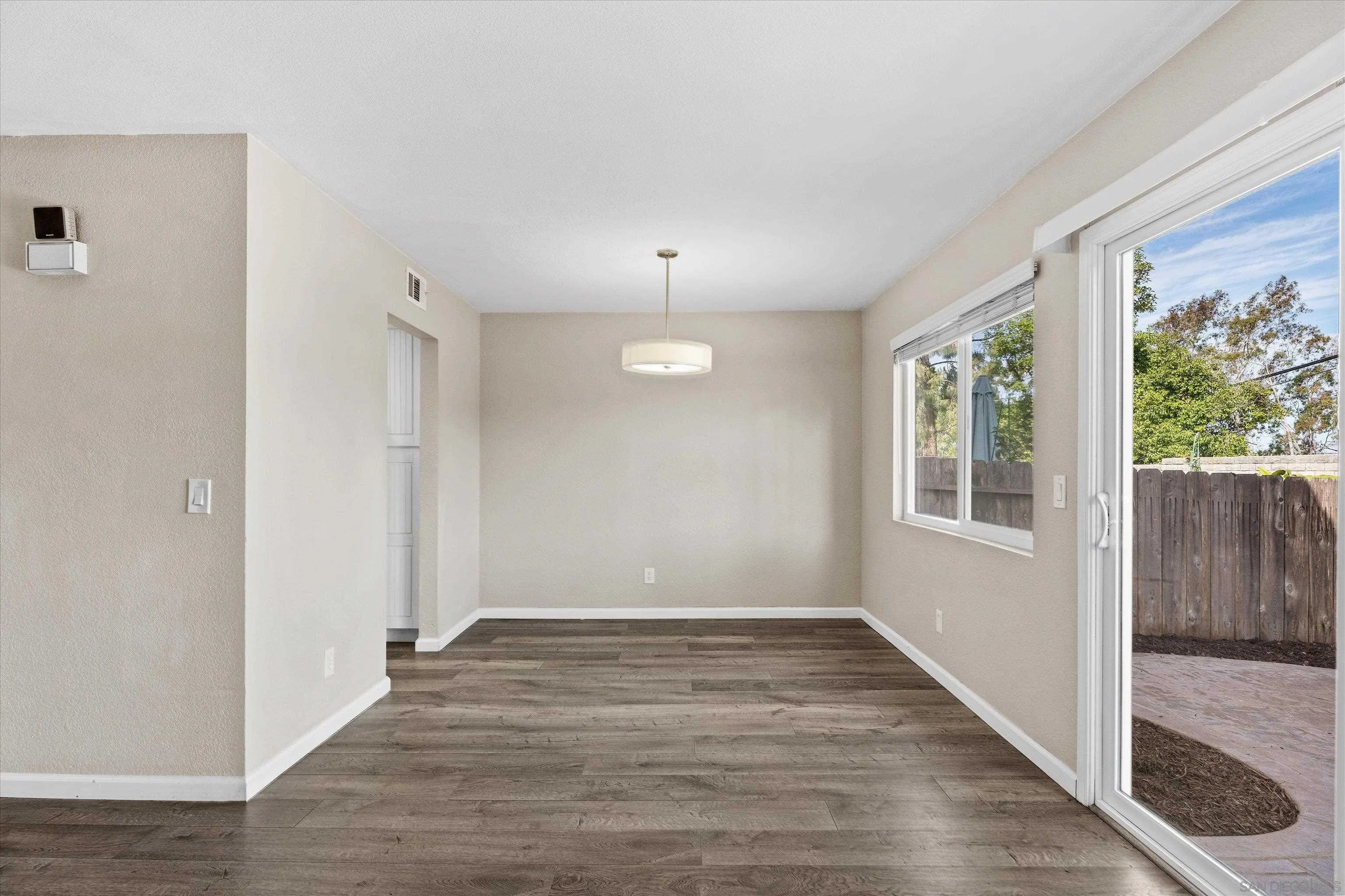 5636 Boot Way Oceanside, CA 92057 - Photo 4 of 36 a view of an empty room with wooden floor and a window