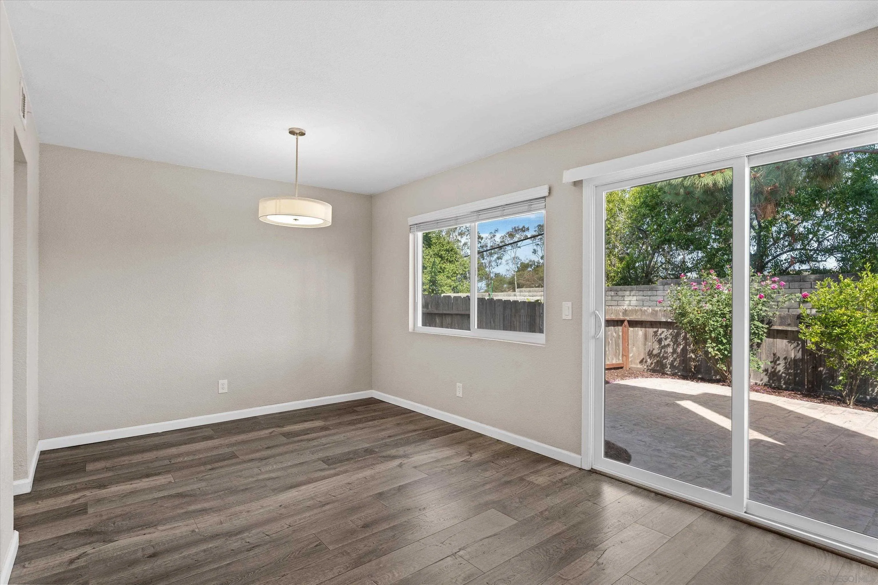 5636 Boot Way Oceanside, CA 92057 - Photo 8 of 36 an empty room with wooden floor and windows