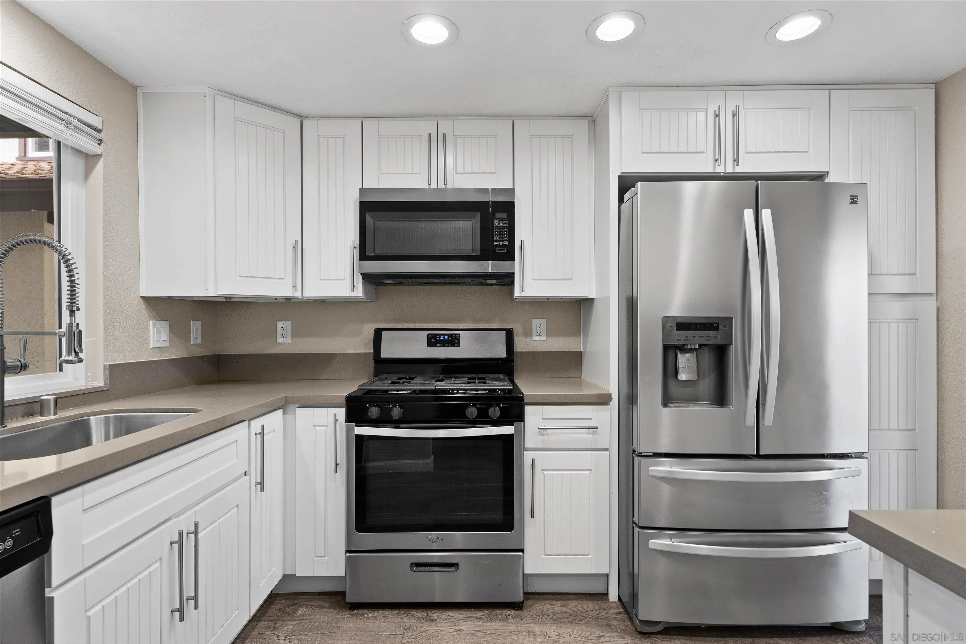 5636 Boot Way Oceanside, CA 92057 - Photo 9 of 36 a kitchen with white cabinets and stainless steel appliances
