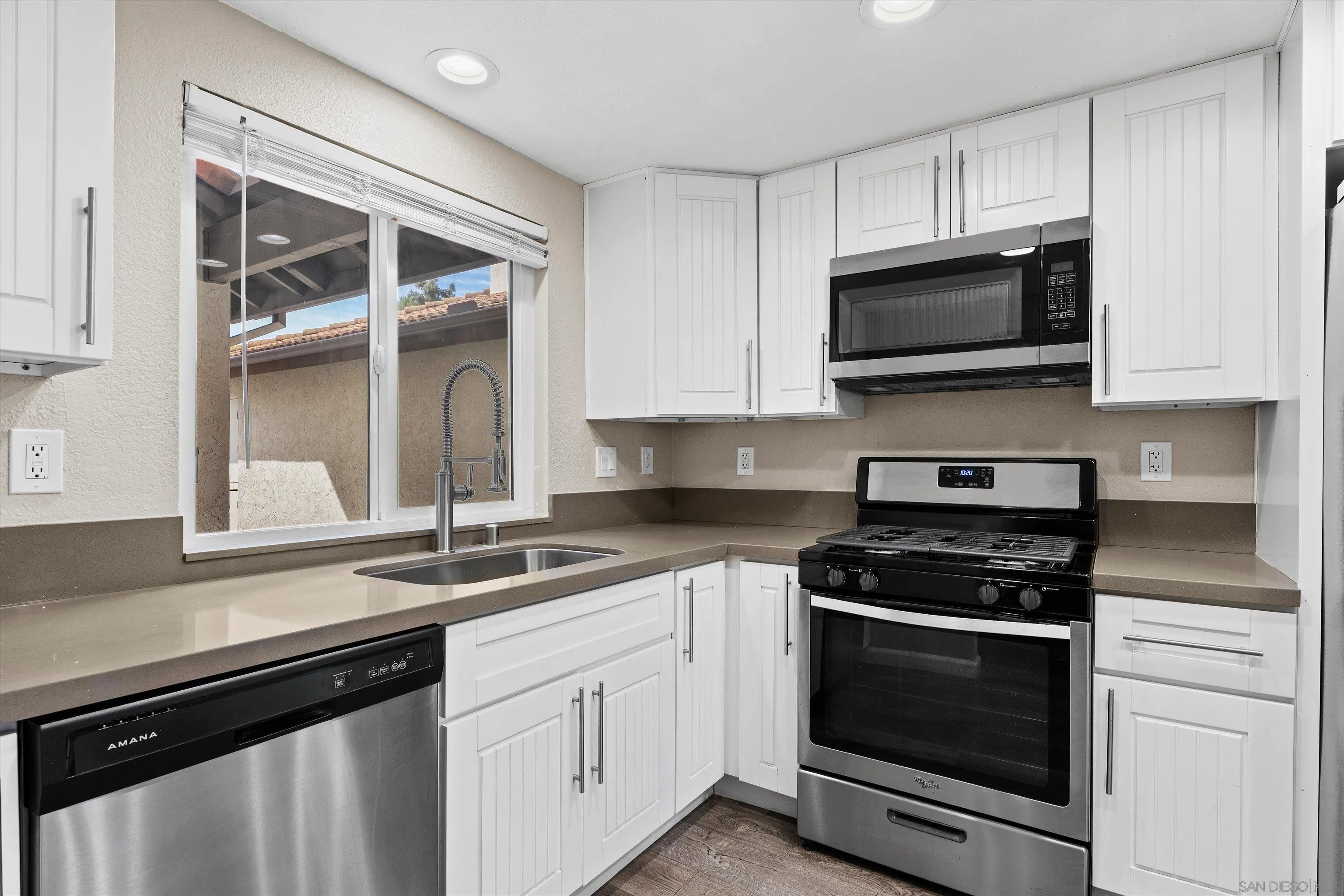 5636 Boot Way Oceanside, CA 92057 - Photo 10 of 36 a kitchen with white cabinets and black appliances
