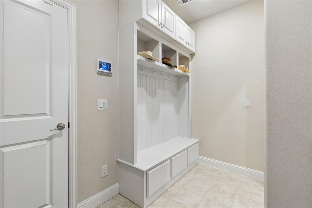 1023 Ridgehurst Road Melissa, TX 75454 - Photo 35 of 39 Built-in white storage unit featuring a bench, three lower cabinets, four open cubbies, and upper cabinetry with paneled doors