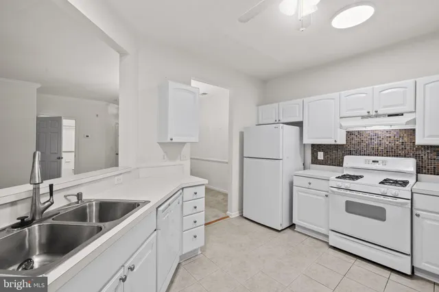 a kitchen with white cabinets and white appliances