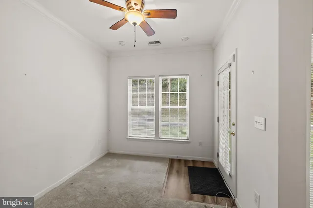 a view of a livingroom with a ceiling fan and windows