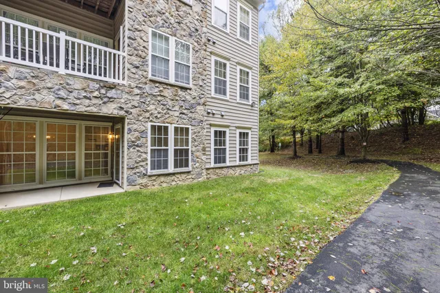 a front view of a house with a garden and tree