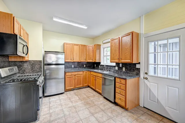 a kitchen with stainless steel appliances granite countertop a stove a sink and a refrigerator