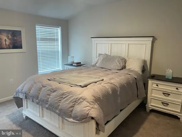 a large bed sitting in a bedroom next to a window