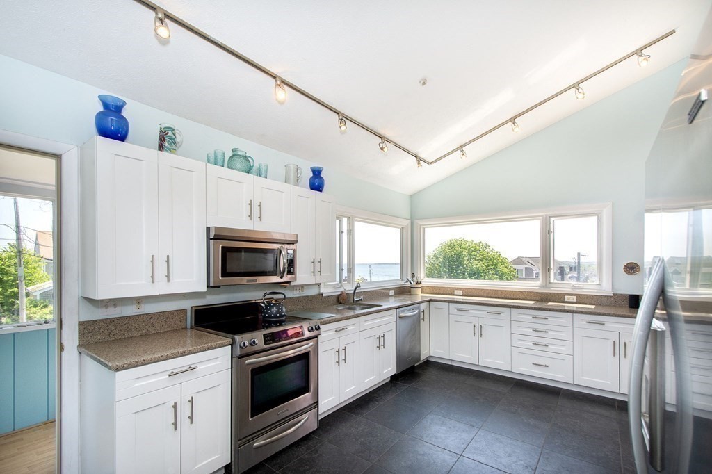 7 Bluff Road Hull, MA 02045 - Photo 9 of 35 a kitchen with granite countertop a sink stainless steel appliances and white cabinets