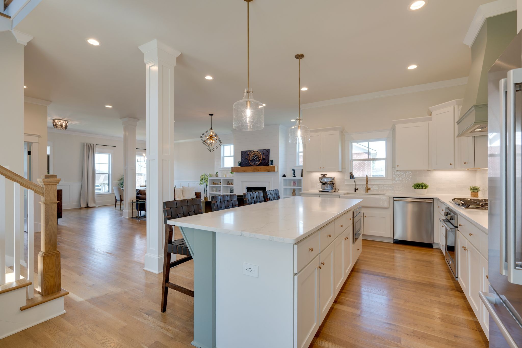 9011 Safehaven Place Spring Hill, TN 37174 - Photo 14 of 49 a large kitchen with white cabinets a sink a stove a dining table and chairs