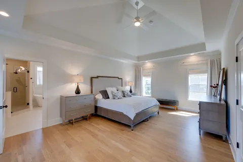 a spacious bedroom with a bed and wooden floor