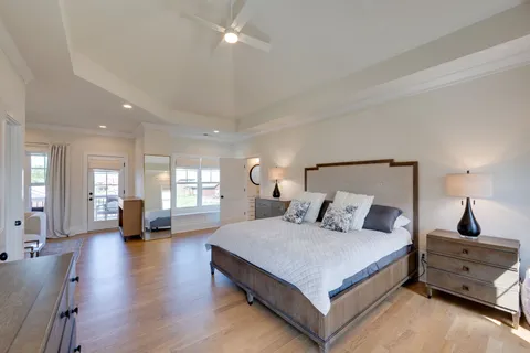 a bedroom with a large bed and wooden floor