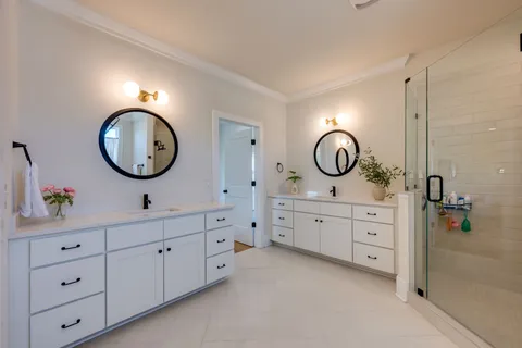 a spacious bathroom with double vanity and a mirror