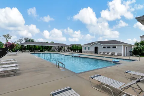 a swimming pool with outdoor seating and barbeque oven