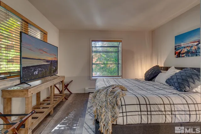 a bedroom with a bed a fireplace and a flat tv screen