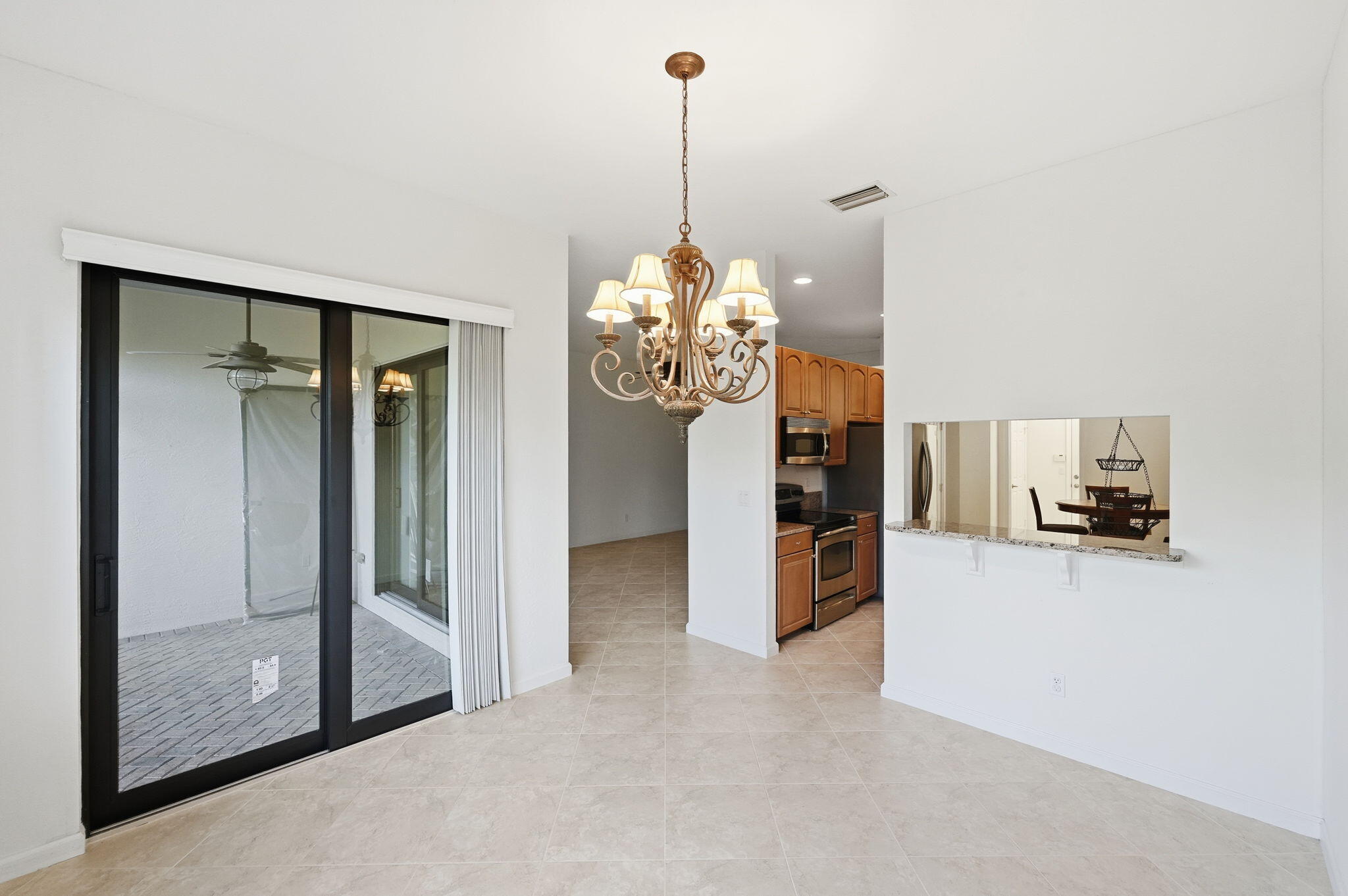 6675 Southeast Woodmill Pond Lane Stuart, FL 34997 - Photo 17 of 61 a view of a dining room with floor to ceiling window and kitchen view