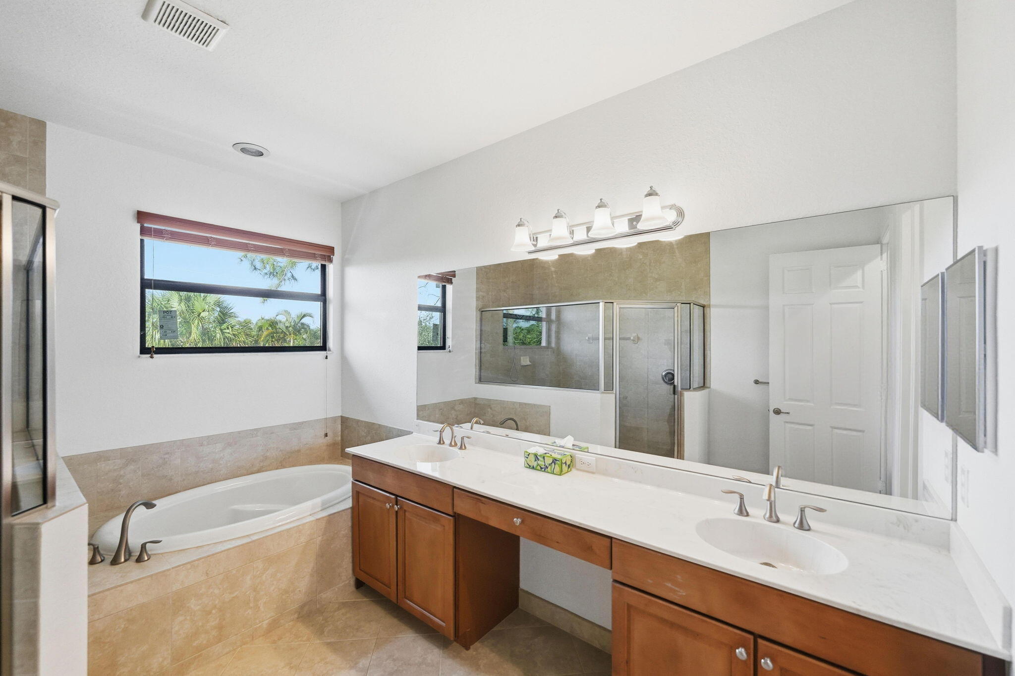 6675 Southeast Woodmill Pond Lane Stuart, FL 34997 - Photo 27 of 61 a bathroom with a tub sink and mirror