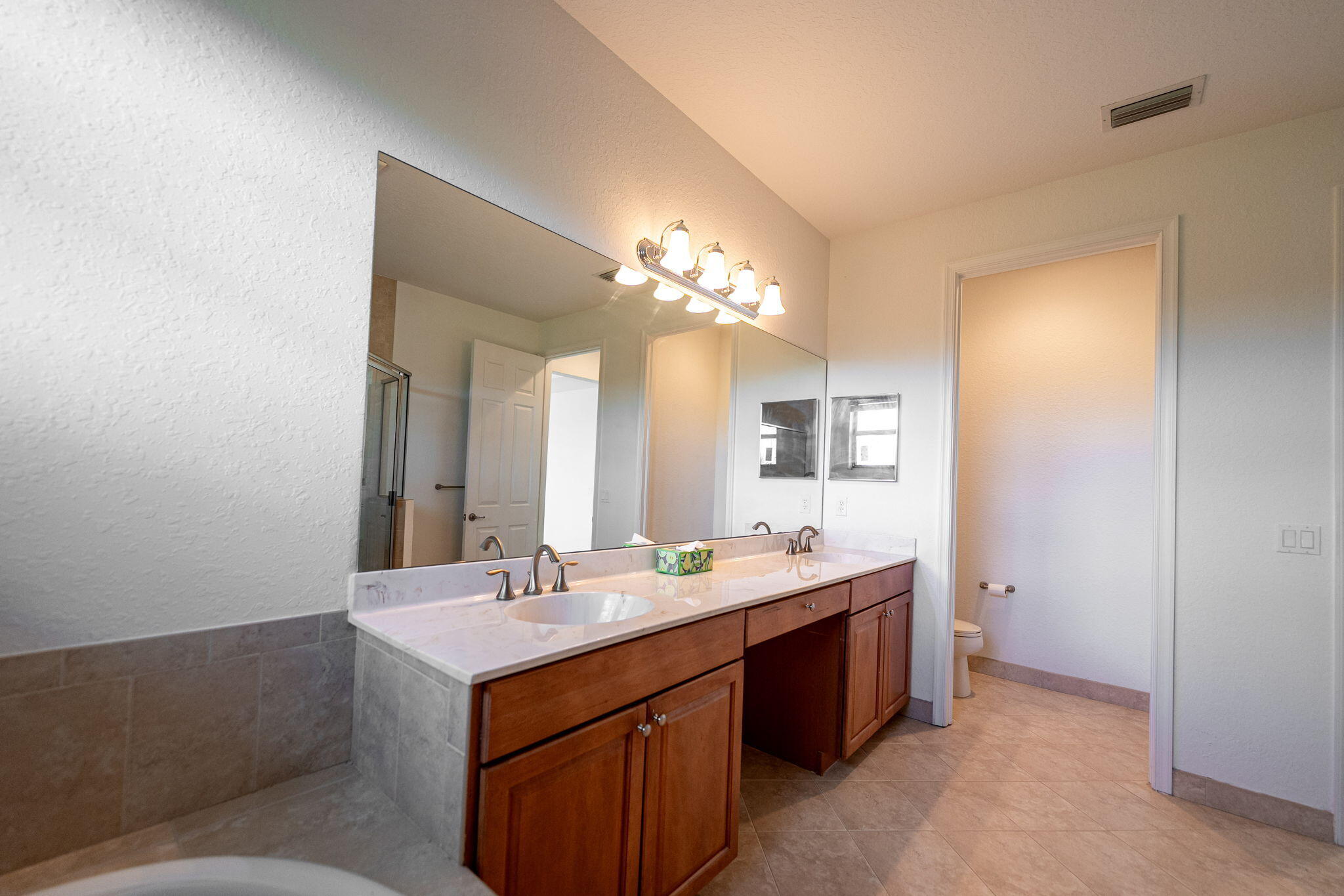 6675 Southeast Woodmill Pond Lane Stuart, FL 34997 - Photo 31 of 61 a bathroom with a double vanity sink and a mirror