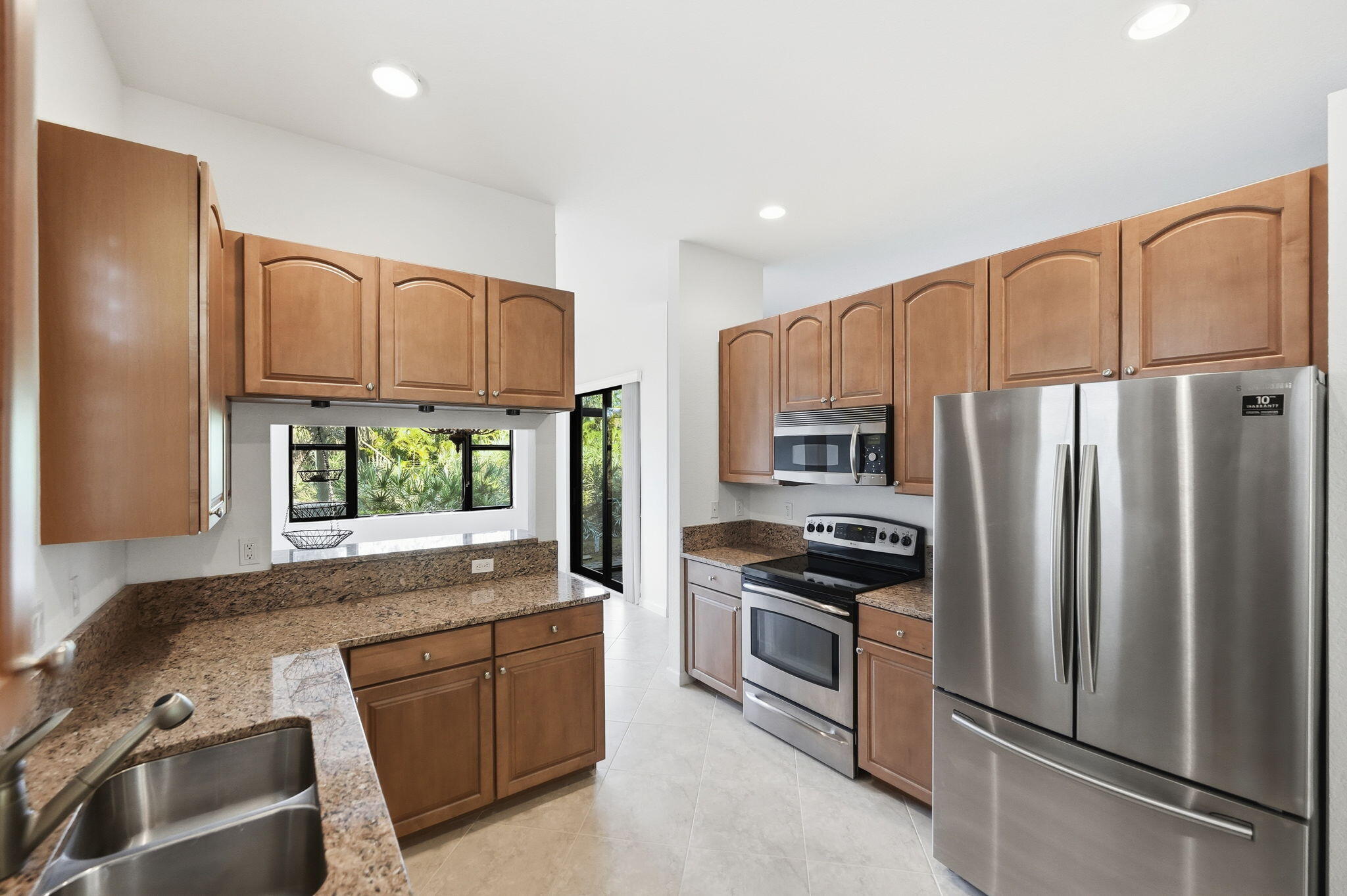 6675 Southeast Woodmill Pond Lane Stuart, FL 34997 - Photo 9 of 61 a kitchen with stainless steel appliances granite countertop a refrigerator stove and oven