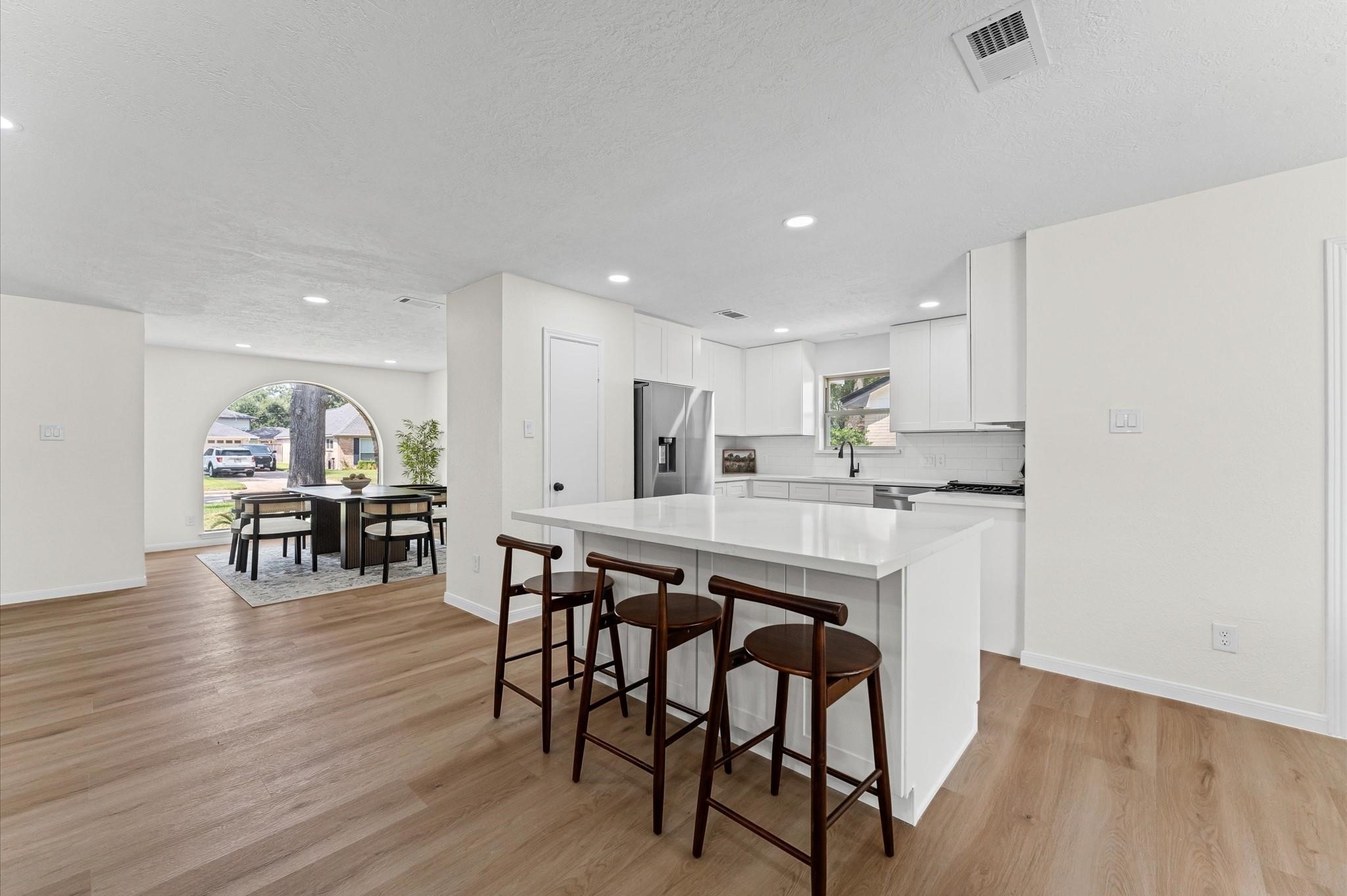 2914 Riata Lane Houston, TX 77043 - Photo 11 of 44 a kitchen with stainless steel appliances a dining table chairs and wooden floor