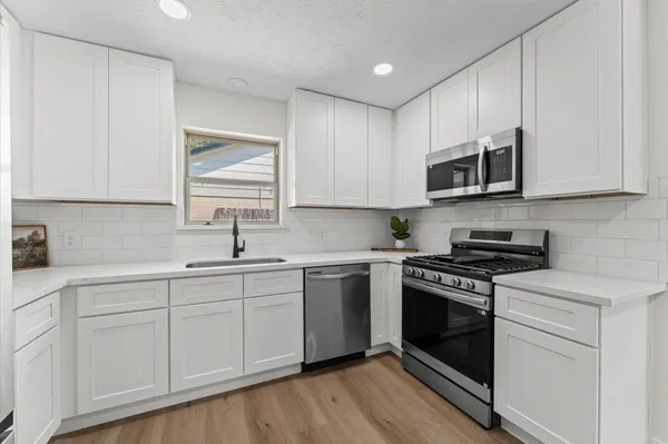 a kitchen with cabinets stainless steel appliances a sink and a counter space