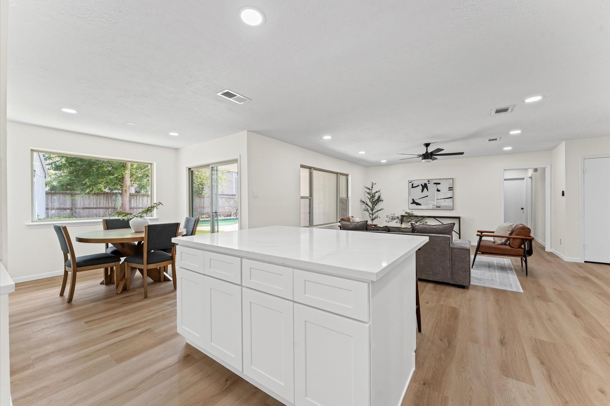 2914 Riata Lane Houston, TX 77043 - Photo 15 of 44 a large white kitchen with stainless steel appliances granite countertop a stove a sink a dining table and chairs with wooden floor