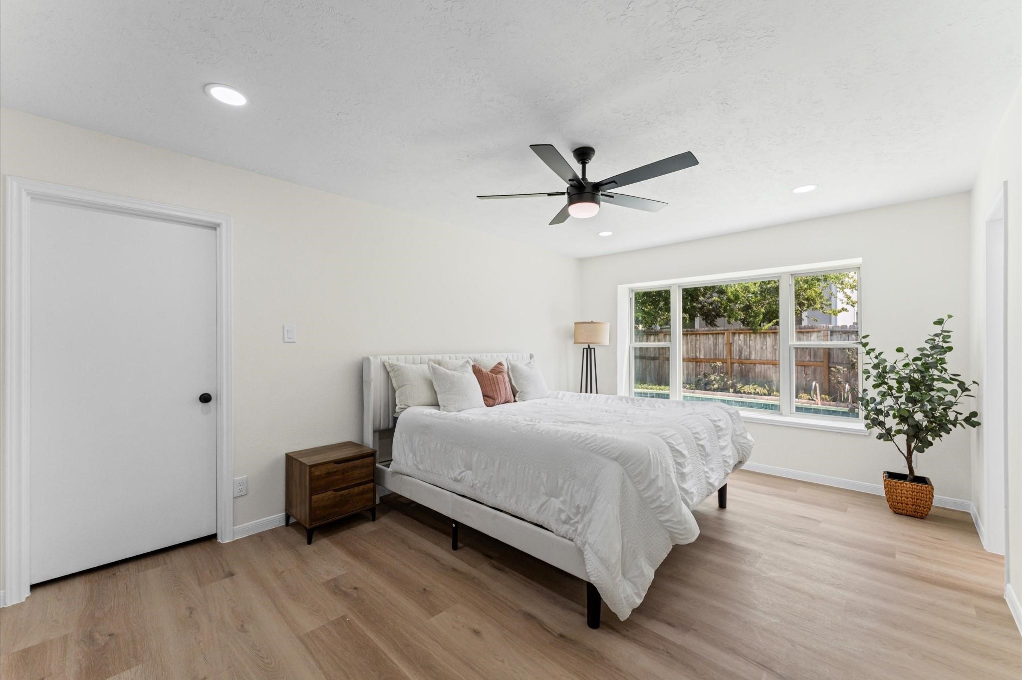 2914 Riata Lane Houston, TX 77043 - Photo 20 of 44 a spacious bedroom with a bed a chandelier and a large window