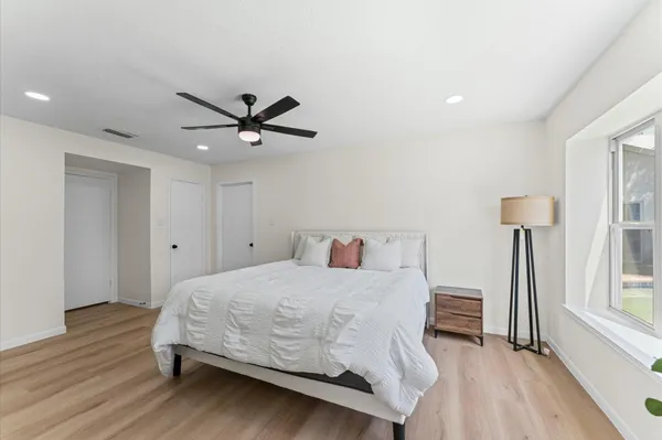 a bedroom with a bed and a ceiling fan