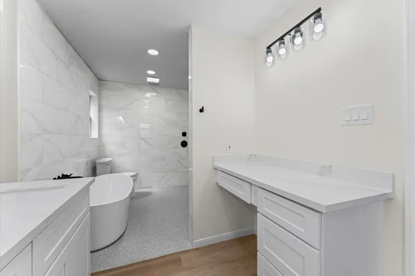 a bathroom with a sink a toilet and shower