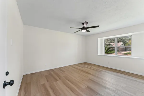 a view of a big room with wooden floor and a ceiling fan