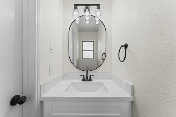 a bathroom with a sink a mirror and a window