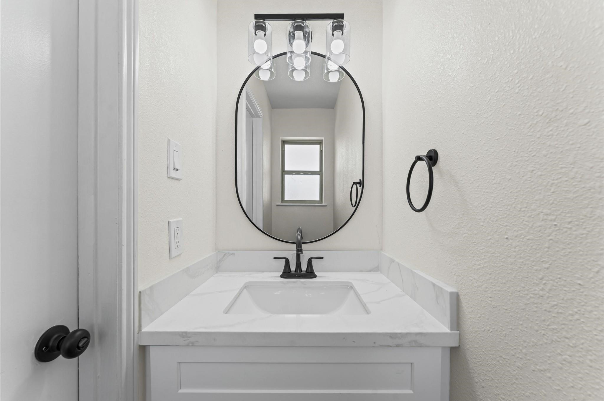 2914 Riata Lane Houston, TX 77043 - Photo 34 of 44 a bathroom with a sink a mirror and a window