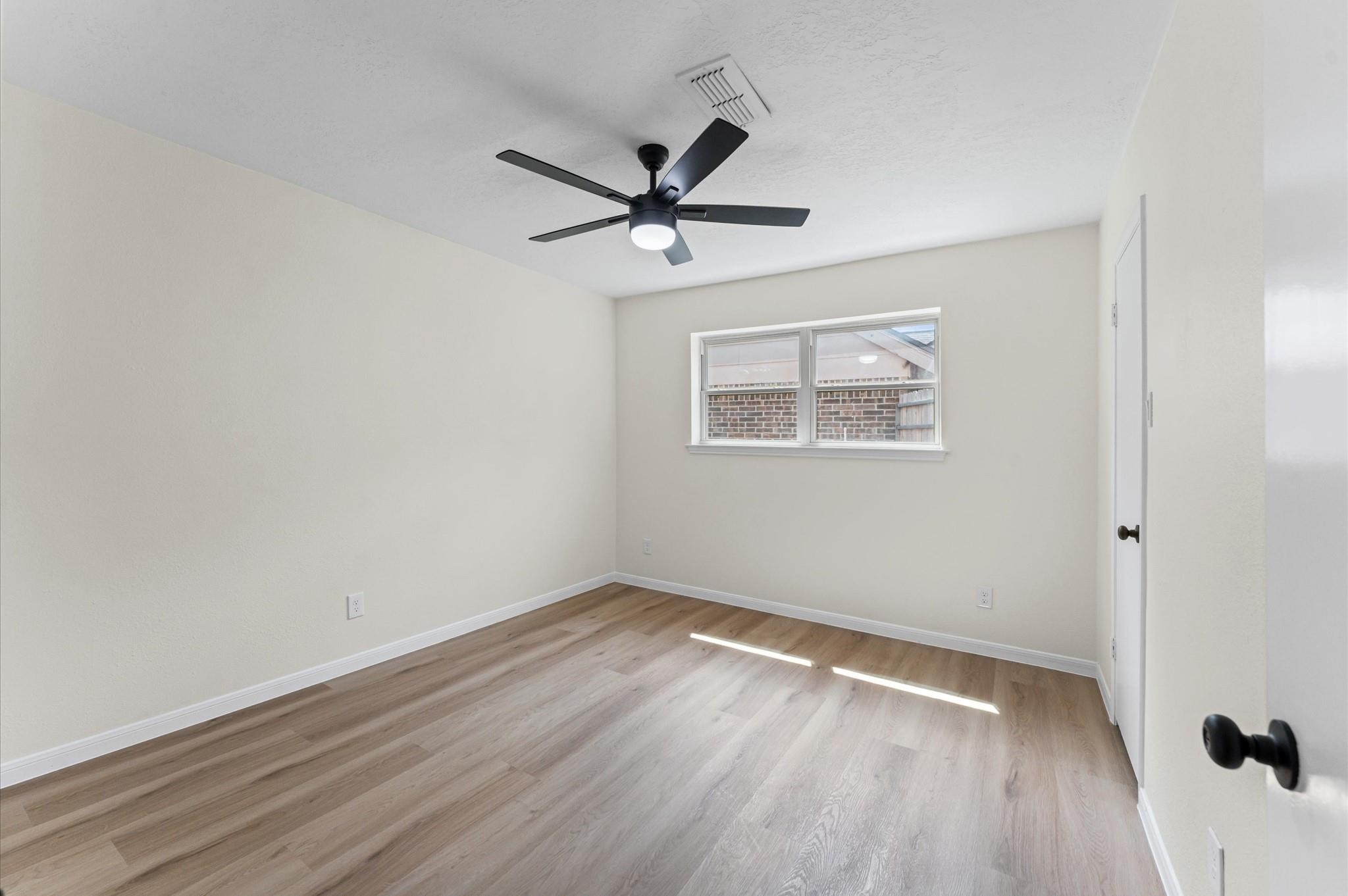 2914 Riata Lane Houston, TX 77043 - Photo 36 of 44 an empty room with wooden floor a ceiling fan and windows
