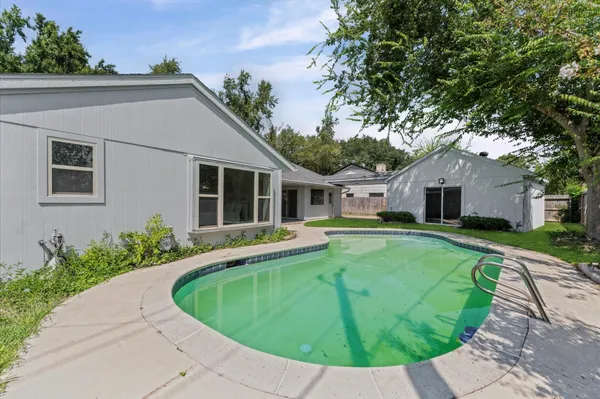 a view of a house with a swimming pool and a yard