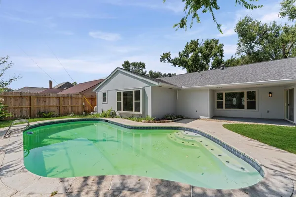 a view of a backyard with swimming pool