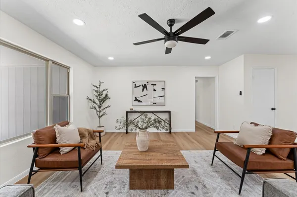 a living room with furniture and a ceiling fan
