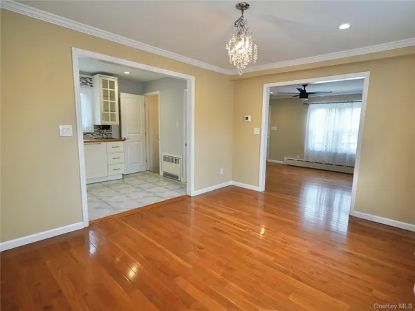 a view of a room with wooden floor and a bathroom