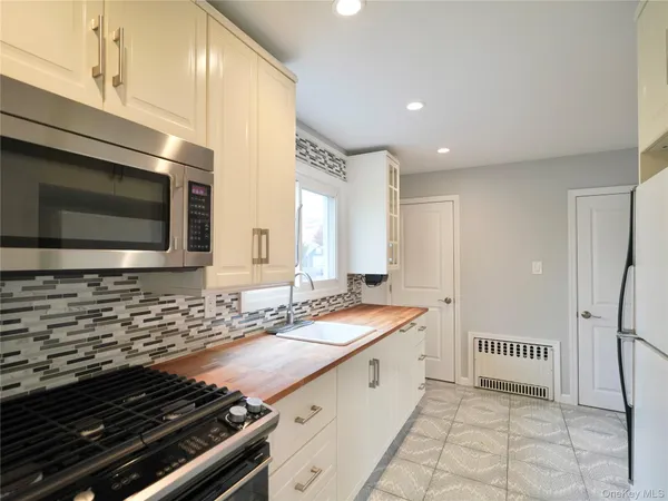 a bathroom with a granite countertop sink and a washing machine