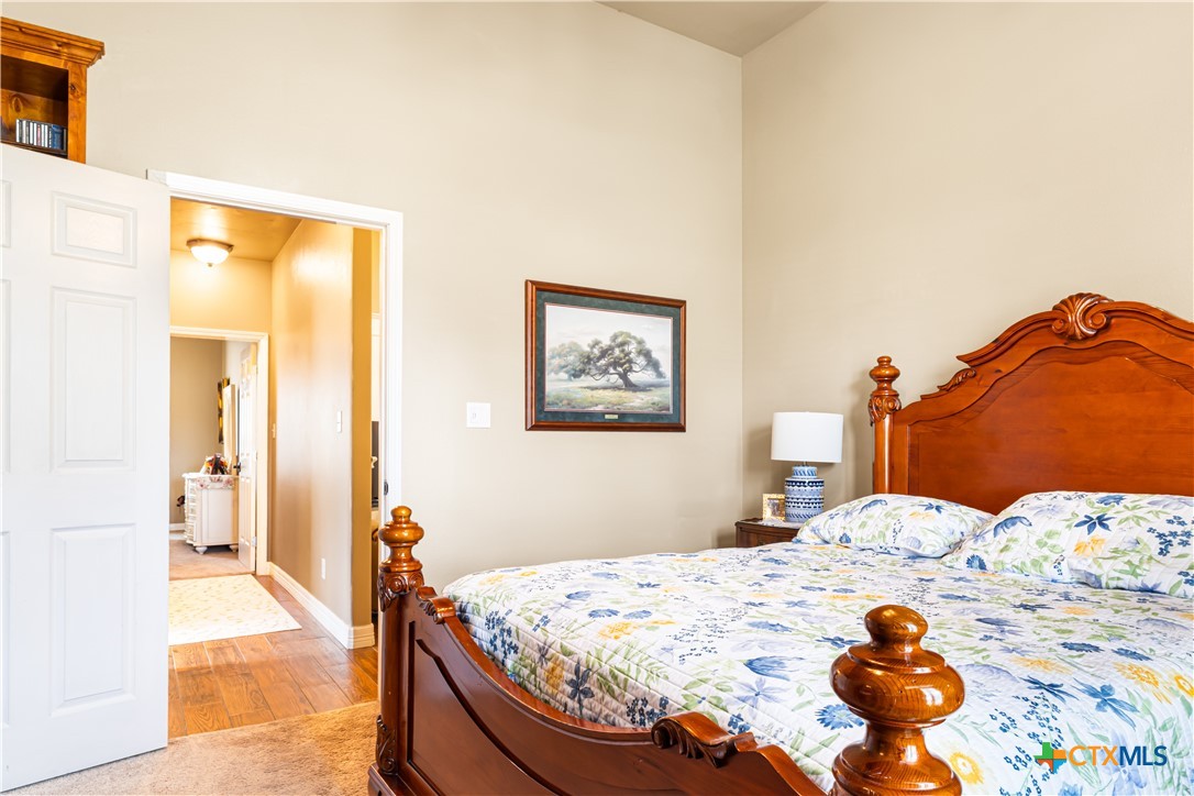 790 Spanish Grant Road Goliad, TX 77963 - Photo 23 of 41 a bedroom with a bed and a painting on the wall
