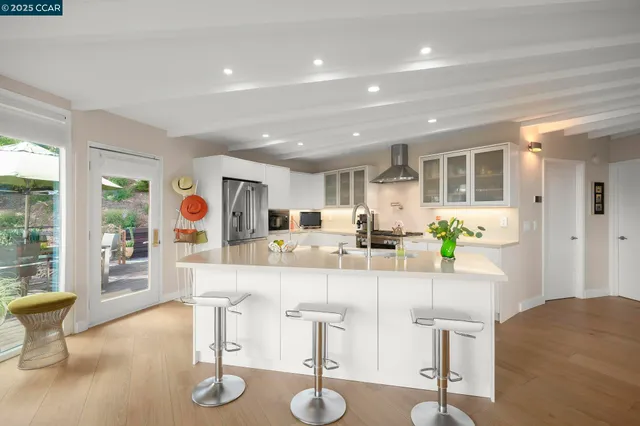 a room with kitchen island a sink and a large window