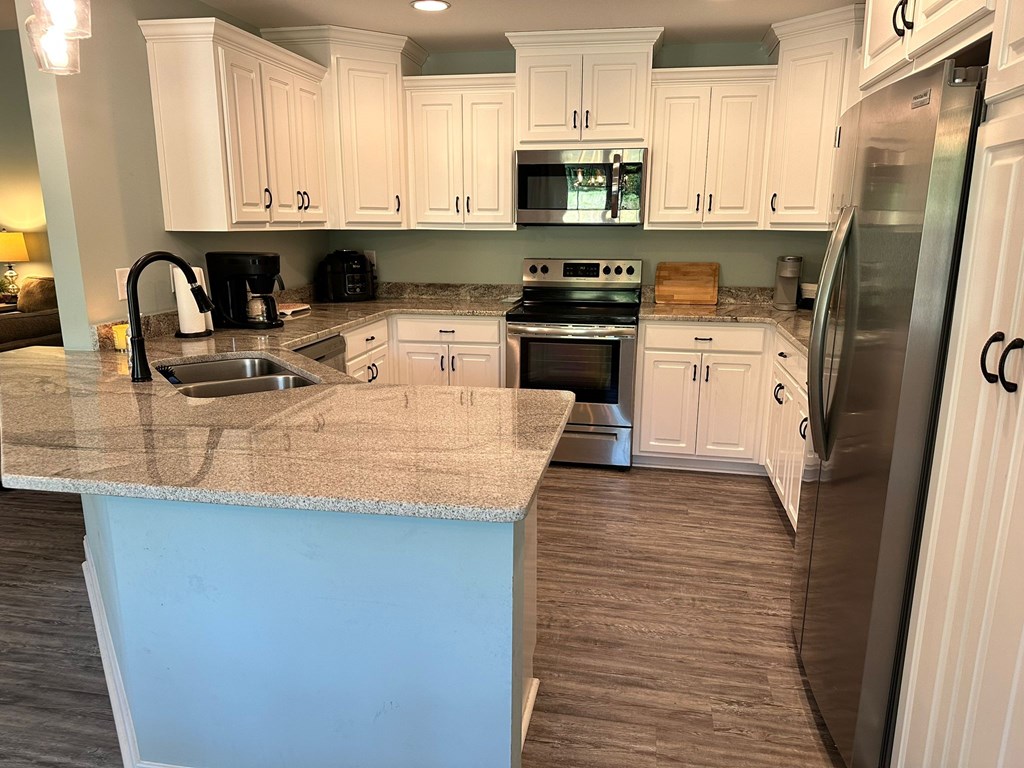 27 Veterans Court Fort Mitchell, AL 36856 - Photo 13 of 31 a kitchen with stainless steel appliances granite countertop a stove a sink dishwasher and a refrigerator with wooden floor