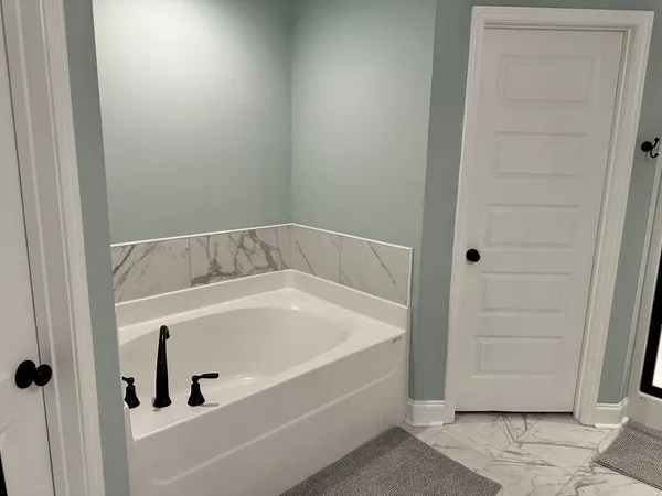 a bathroom with a granite countertop sink a mirror and shower