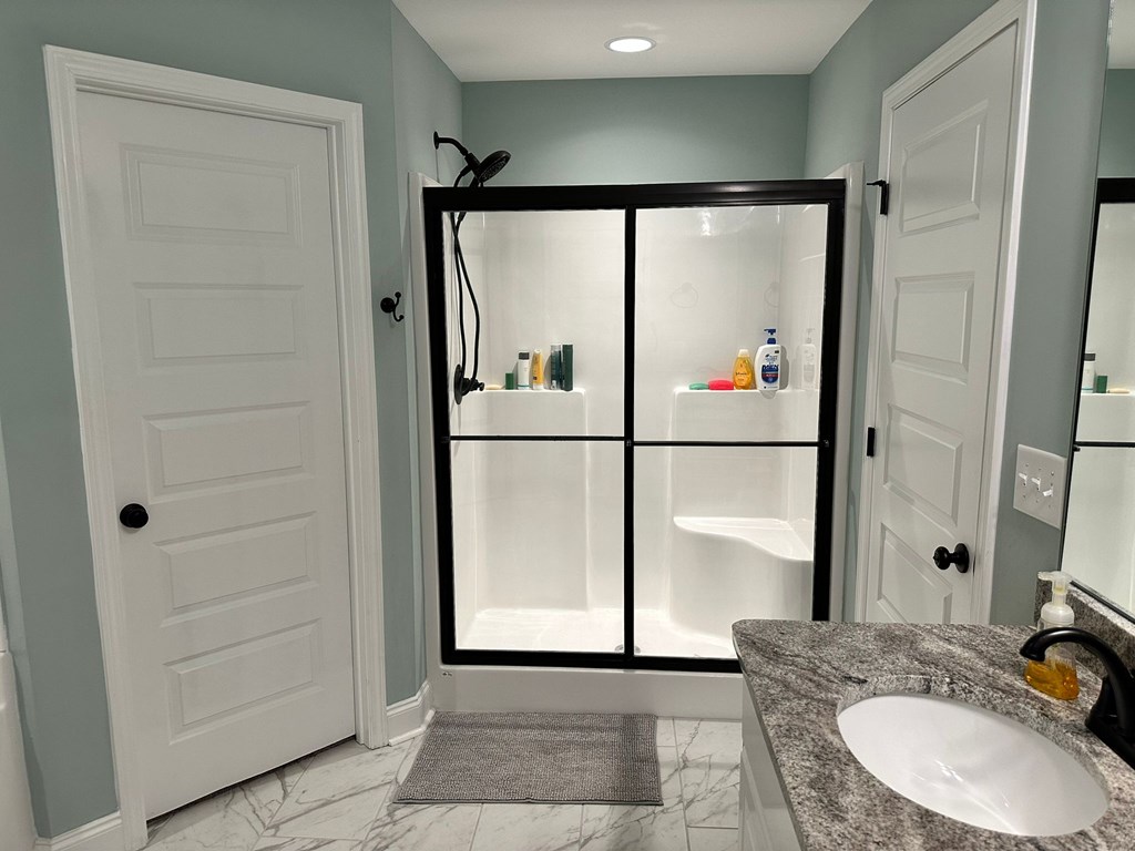 27 Veterans Court Fort Mitchell, AL 36856 - Photo 19 of 31 a bathroom with a granite countertop sink a mirror and shower