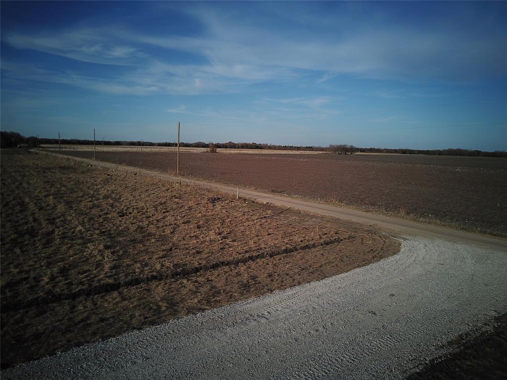 0 Southeast 4060 Road Kerens, TX 75144 - Photo 4 of 6 Expansive land featuring a gravel road, open fields, and utilities.