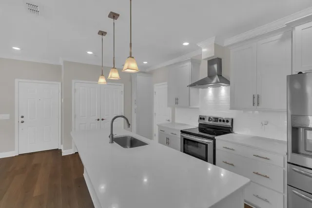 a kitchen with granite countertop a sink a stove and refrigerator