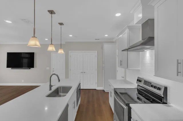 a kitchen with sink a refrigerator and a stove